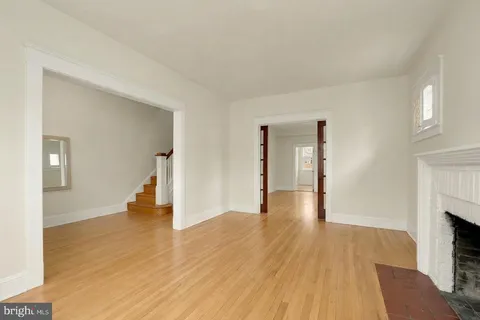 a view of a livingroom with wooden floor and a fireplace