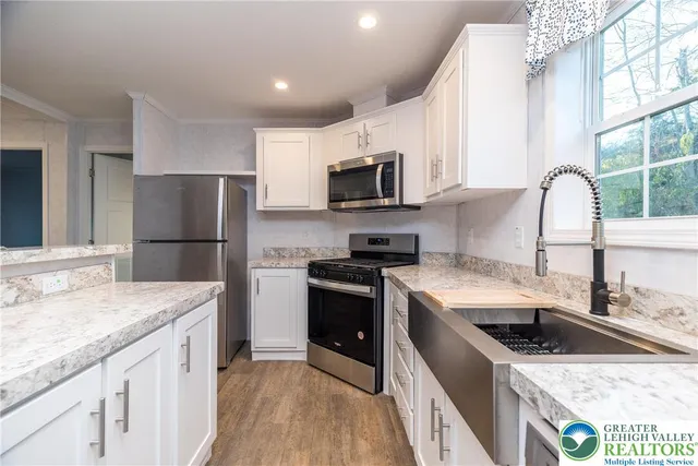 a kitchen with a sink a microwave a refrigerator and cabinets