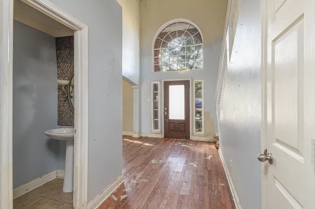 a view of a hallway with wooden floor and a bathroom