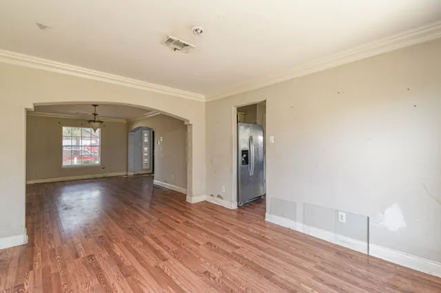 a view of empty room with wooden floor and window