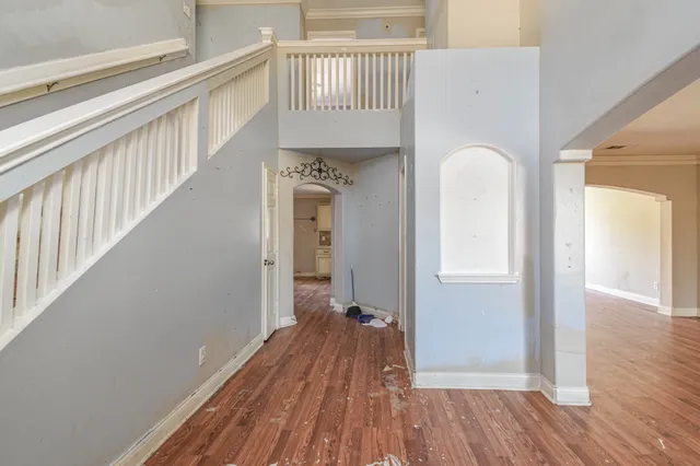 a view of a hallway with wooden floor and staircase