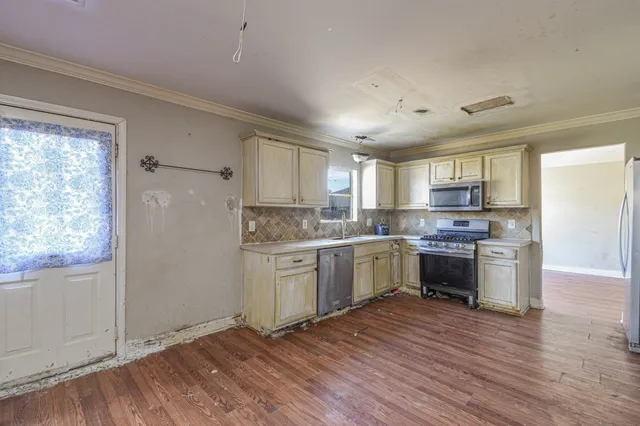 a kitchen with granite countertop a refrigerator and wooden cabinets