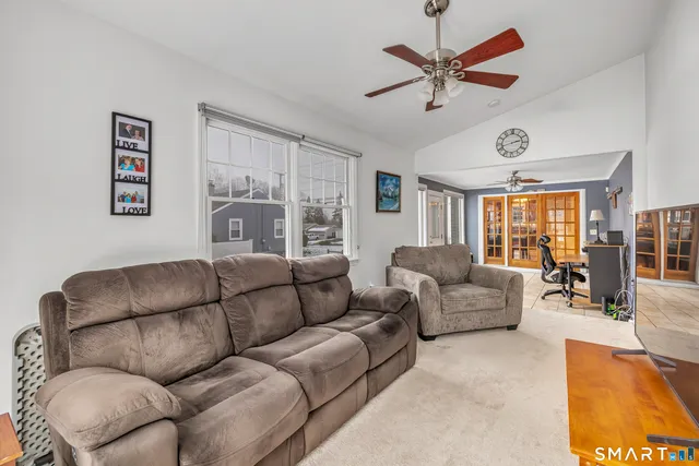 a living room with furniture ceiling fan and a rug