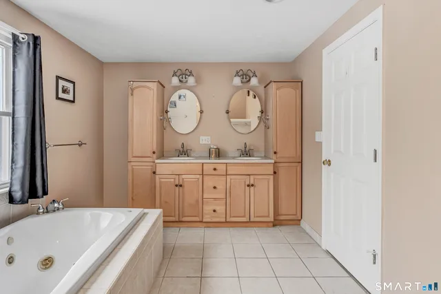 a bathroom with a tub a sink and a mirror