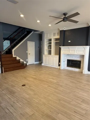 an empty room with windows fireplace and fans
