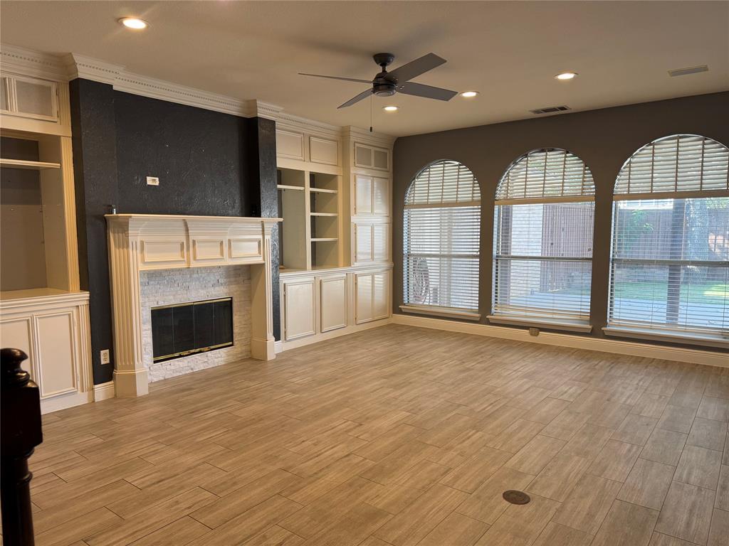 413 Ridge Meade Drive Lewisville, TX 75067 - Photo 23 of 23 an empty room with windows fireplace and fans