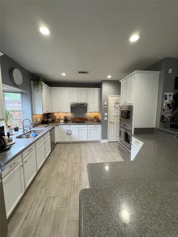 a large kitchen with stainless steel appliances lots of counter top space