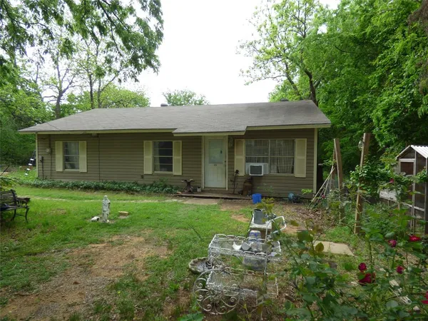 a backyard of a house with yard table and chairs