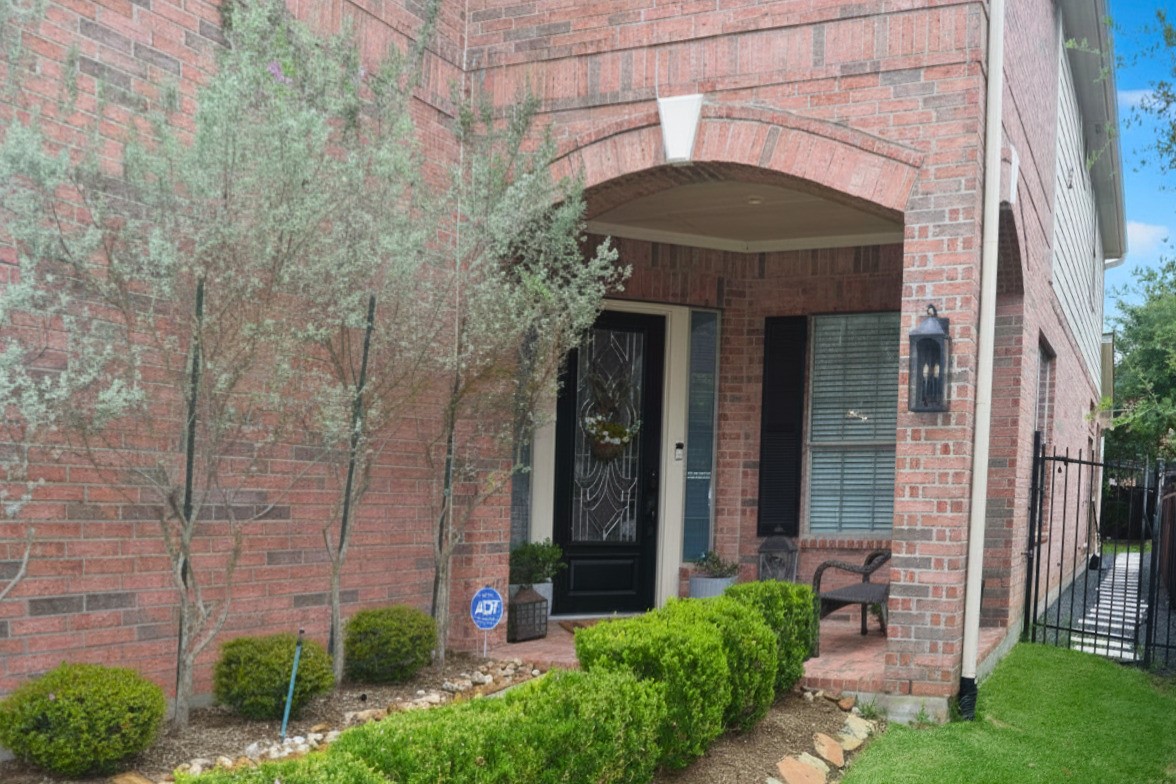 26 Winhall Place The Woodlands, TX 77354 - Photo 3 of 8 Charming covered entry with elegant architectural details and lush landscaping.