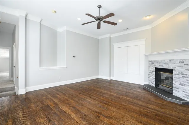 a large kitchen with stainless steel appliances granite countertop a stove a sink a refrigerator and white cabinets with wooden floor