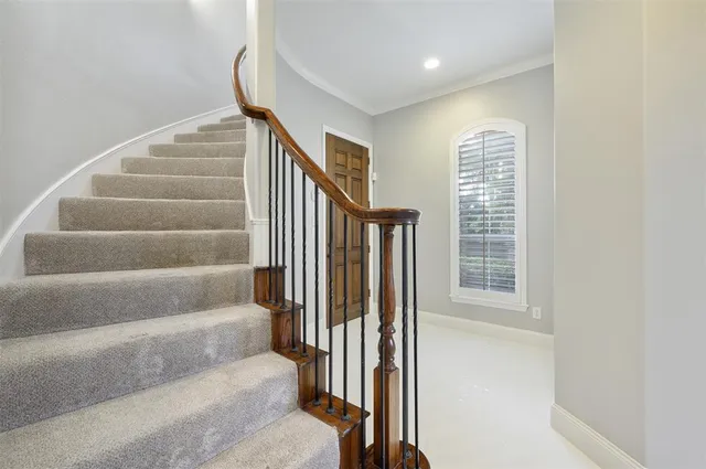 a view of staircase with white walls and a window