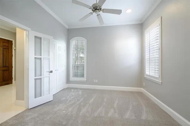 an empty room with wooden floor and way to kitchen