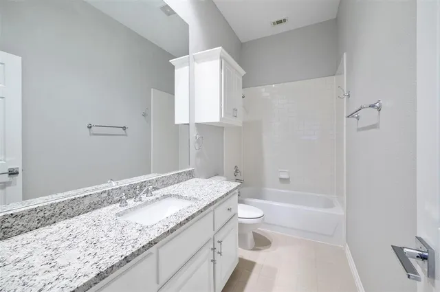 a view of a livingroom with a fireplace a ceiling fan and a kitchen view
