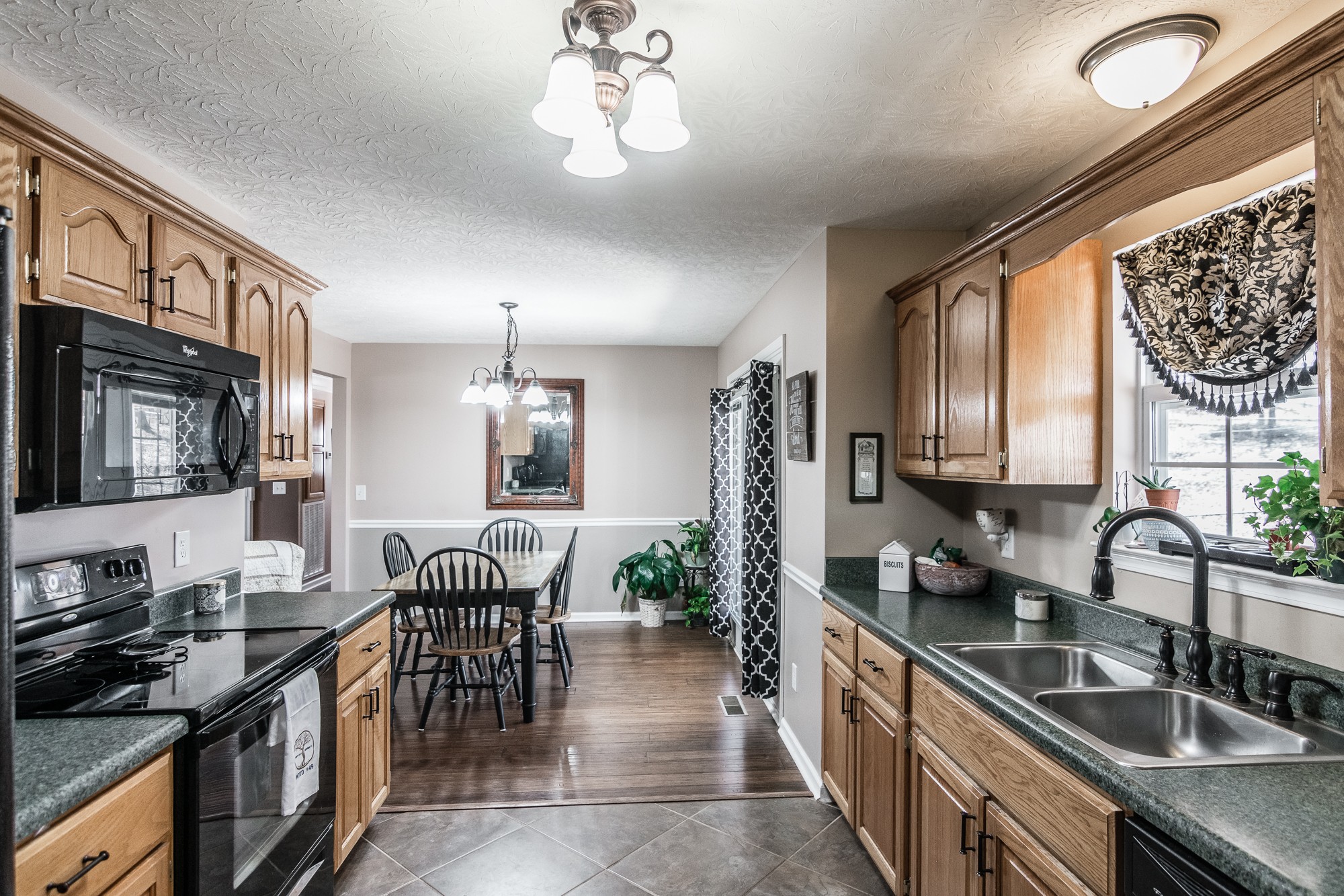 166 Switchboard Road Portland, TN 37148 - Photo 14 of 49 a kitchen with stainless steel appliances granite countertop a stove top oven a sink a dining table and chairs with wooden floor