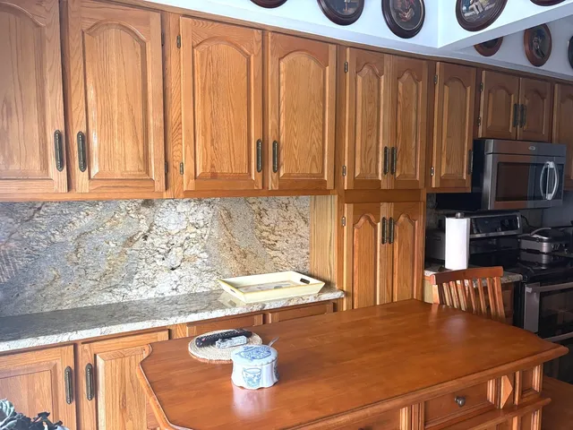 a kitchen with stainless steel appliances granite countertop a refrigerator stove and microwave