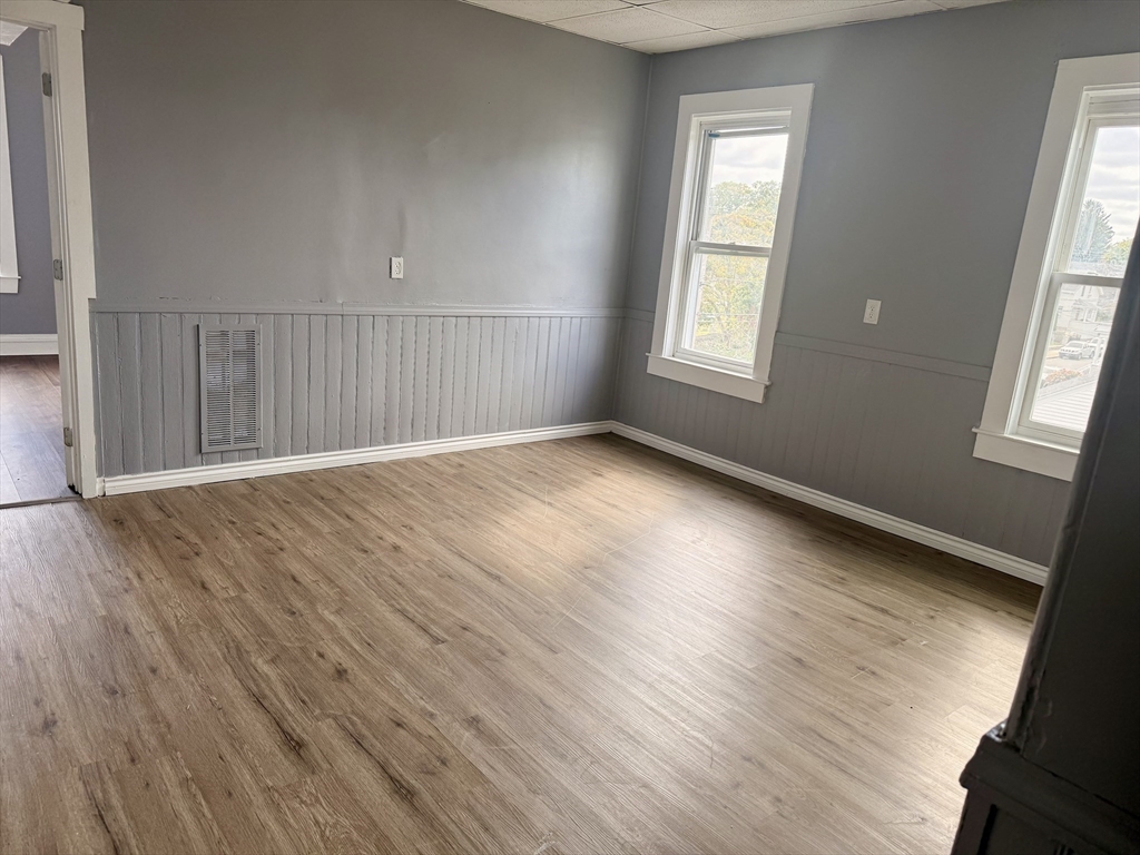 270 Stetson Street, Unit 3 Fall River, MA 02720 - Photo 2 of 9 a view of an empty room with wooden floor and a window
