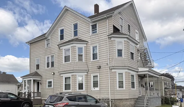 a front view of a residential apartment building with a yard