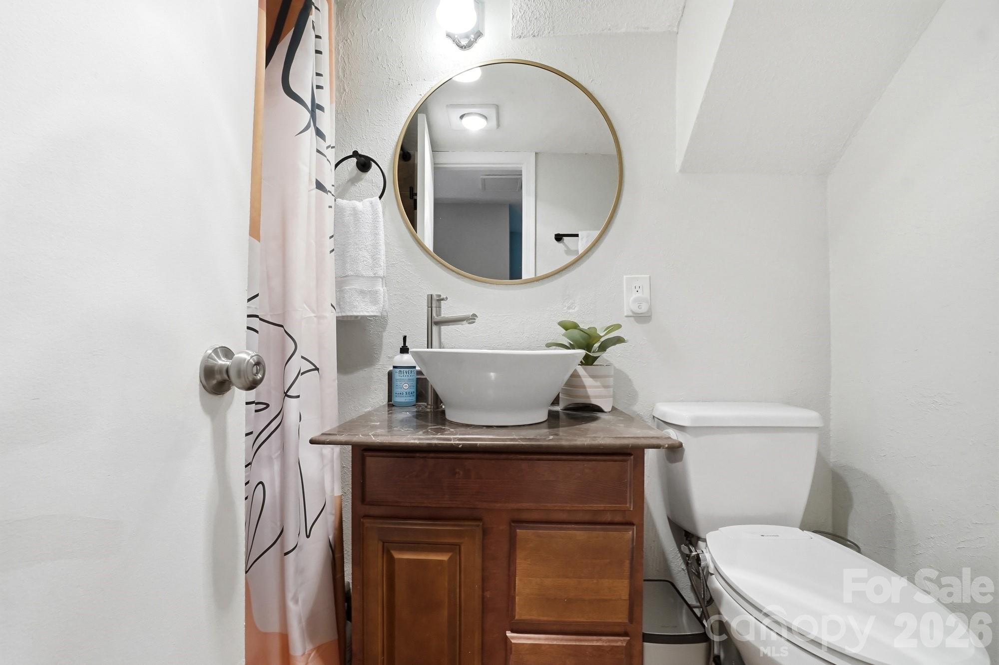 824 Riverwood Road Charlotte, NC 28270 - Photo 24 of 37 a bathroom with a toilet a sink and a mirror