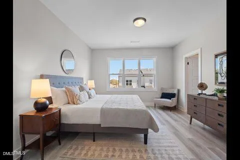 a bedroom with a bed and wooden floor