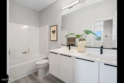 a bathroom with a granite countertop toilet sink and mirror