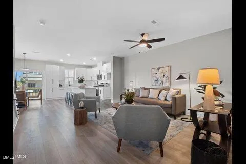 a living room with furniture a table and wooden floor