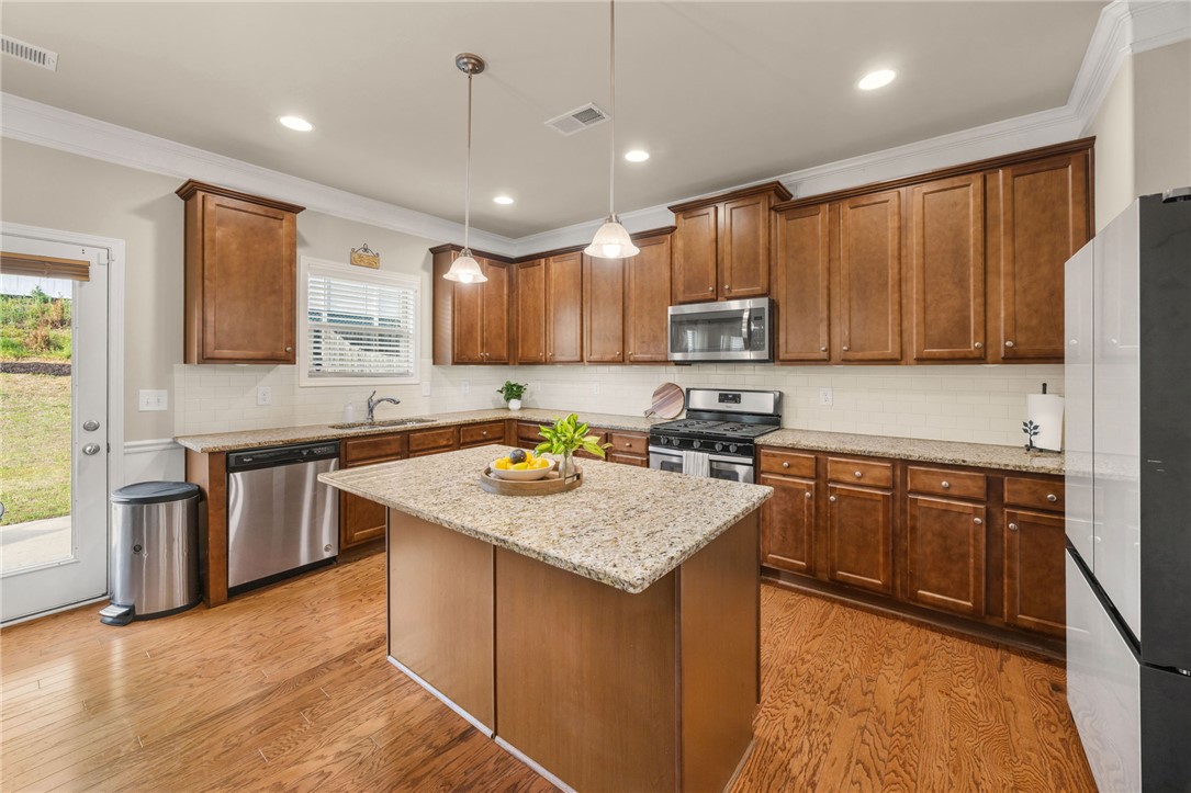 874 Wild Orchard Lane Woodruff, SC 29388 - Photo 28 of 35 This kitchen offers warm wood cabinetry and a spacious island, ideal for cooking and entertaining.