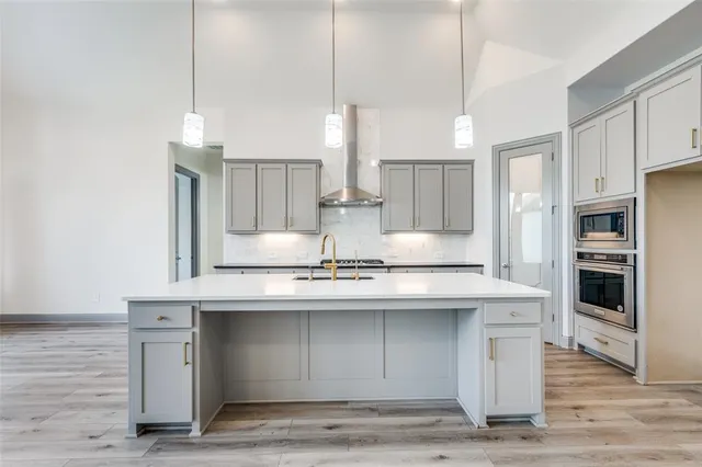 a kitchen with stainless steel appliances granite countertop a sink a stove and a refrigerator