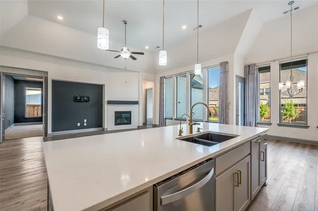 a kitchen with stainless steel appliances granite countertop a sink a oven a counter space and a window