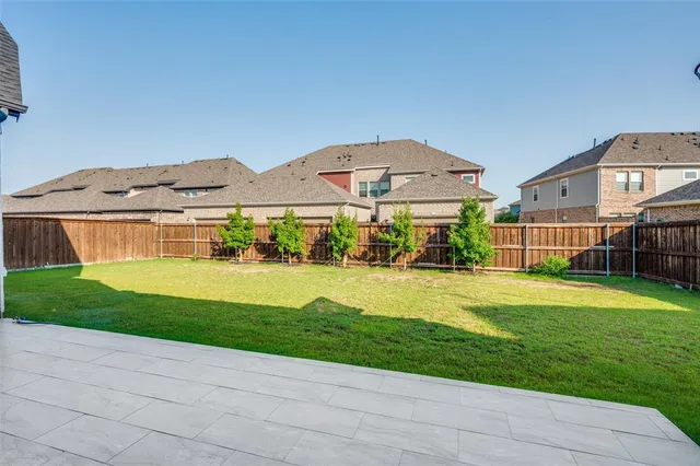 a view of a big house with a big yard and large trees