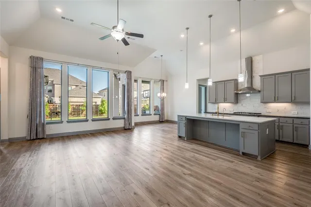 a large white kitchen with a large window a sink and appliances