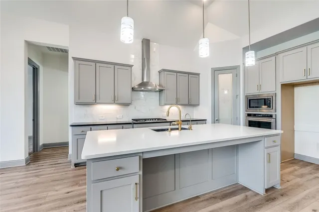 a kitchen with kitchen island white cabinets and stainless steel appliances