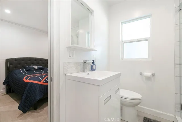 a bathroom with a double vanity sink a toilet and a bathtub