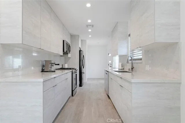 a large kitchen with stainless steel appliances kitchen island granite countertop a sink and cabinets