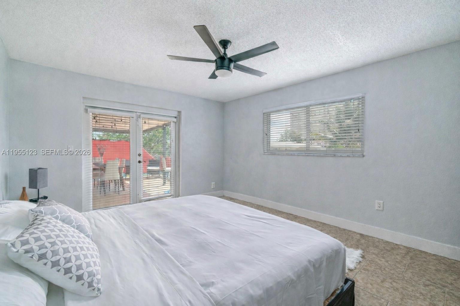 901 Northwest 22nd Place Miami, FL 33125 - Photo 25 of 52 a bedroom with a large bed and a chandelier