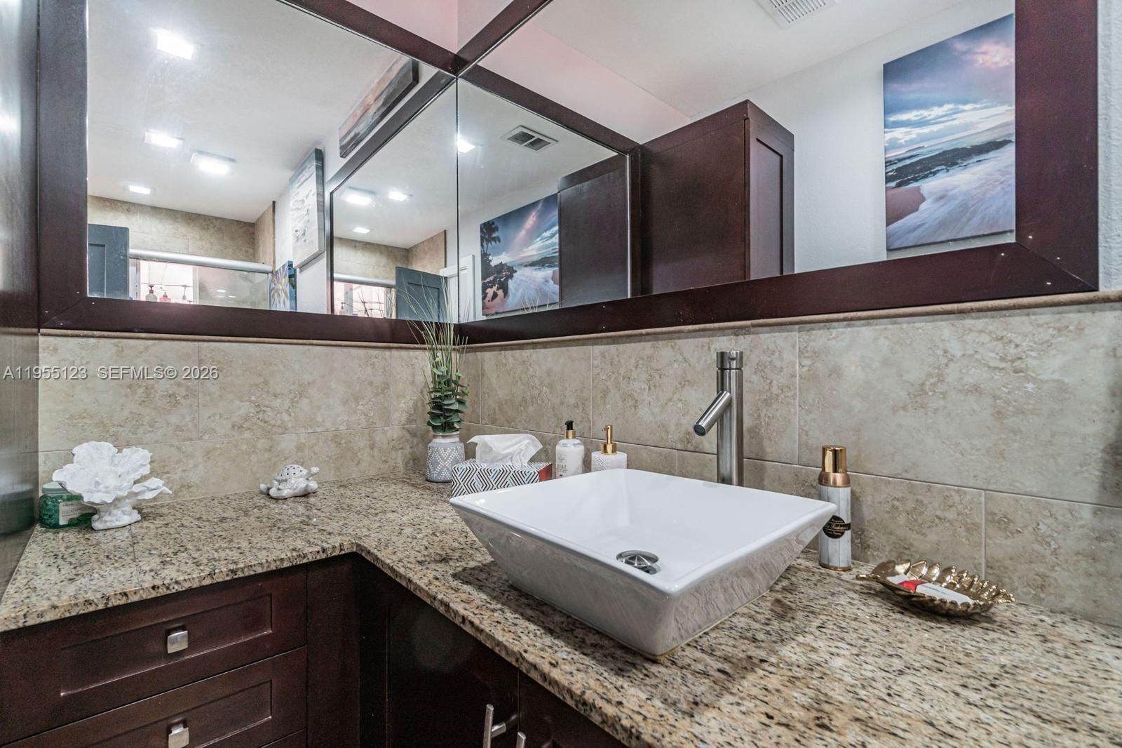 901 Northwest 22nd Place Miami, FL 33125 - Photo 27 of 52 a bathroom with a granite countertop sink and a mirror