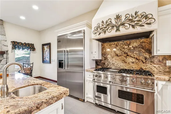 a kitchen with granite countertop a sink stove and cabinets