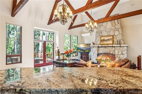 a bedroom with a bed a dresser and large windows