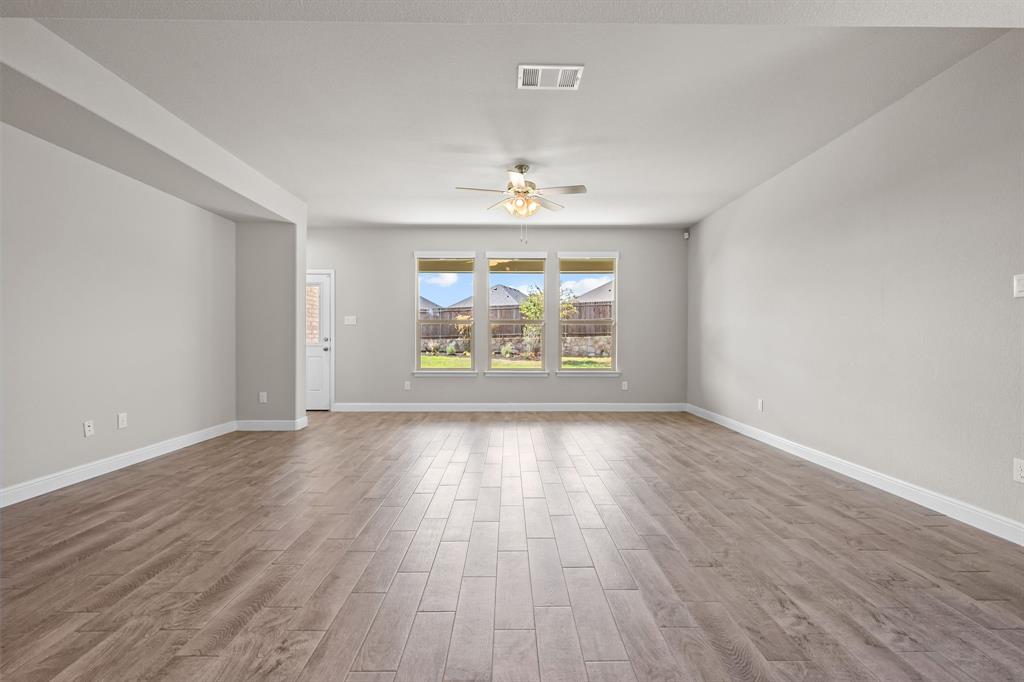1840 Ruffian Road Granbury, TX 76049 - Photo 5 of 33 Spacious room featuring wood-finish flooring, light gray walls, and a ceiling fan