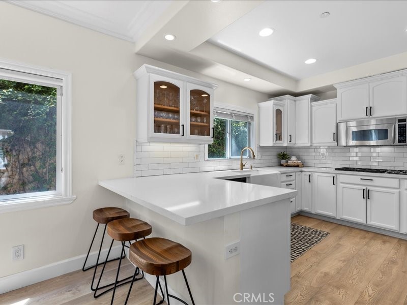1729 Haynes Lane Redondo Beach, CA 90278 - Photo 5 of 44 a kitchen with stainless steel appliances granite countertop a sink a stove a refrigerator cabinets and a dining table with wooden floor