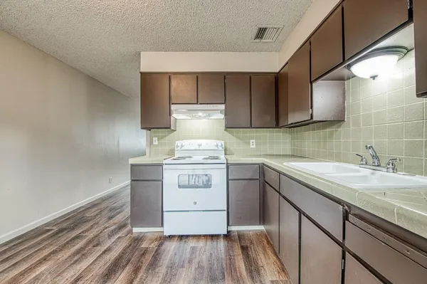 a kitchen with a sink stove and cabinets