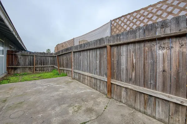 a view of backyard with wooden fence