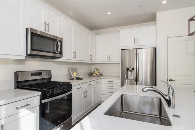 a kitchen with granite countertop a sink and stainless steel appliances
