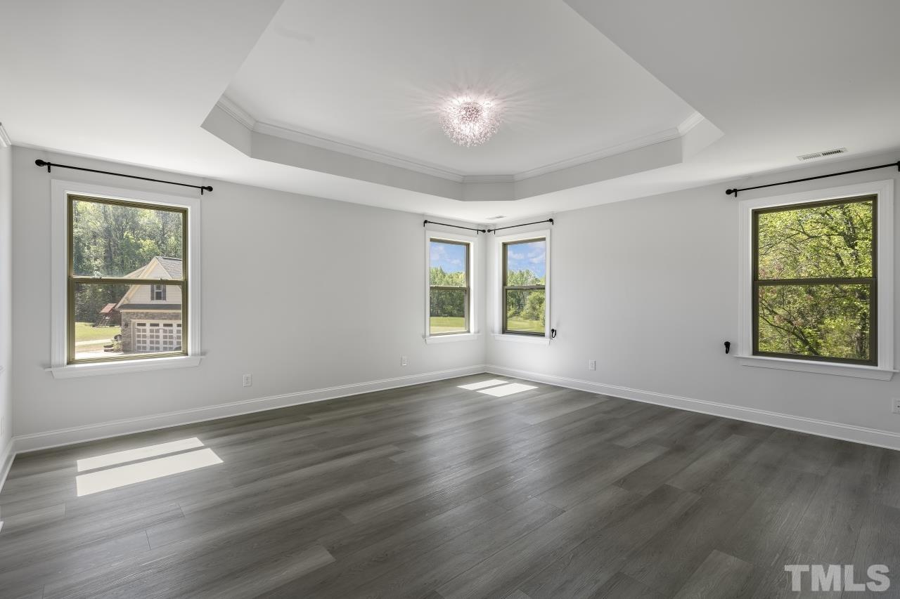 8340 Yellow Aster Court Willow Spring, NC 27592 - Photo 19 of 35 a view of an empty room with wooden floor and a window
