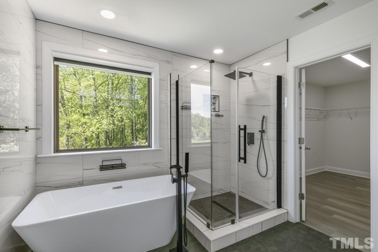 8340 Yellow Aster Court Willow Spring, NC 27592 - Photo 20 of 35 a bathroom with a shower and a bathtub