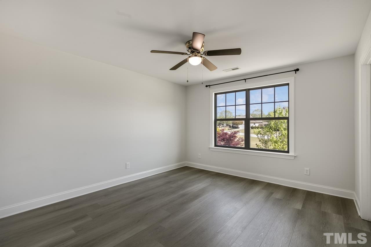 8340 Yellow Aster Court Willow Spring, NC 27592 - Photo 23 of 35 an empty room with wooden floor ceiling fan and windows