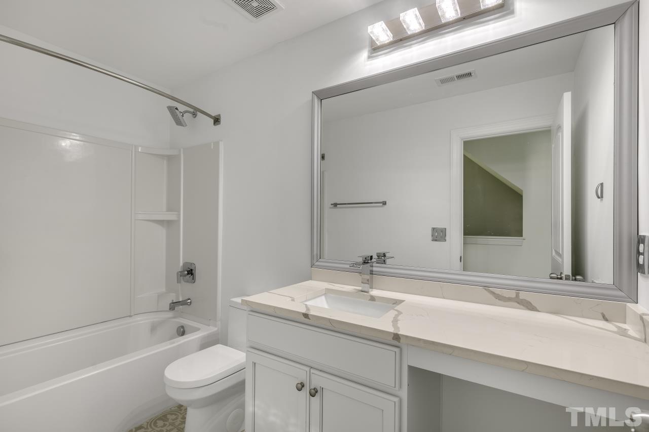 8340 Yellow Aster Court Willow Spring, NC 27592 - Photo 24 of 35 a bathroom with a sink a toilet and shower
