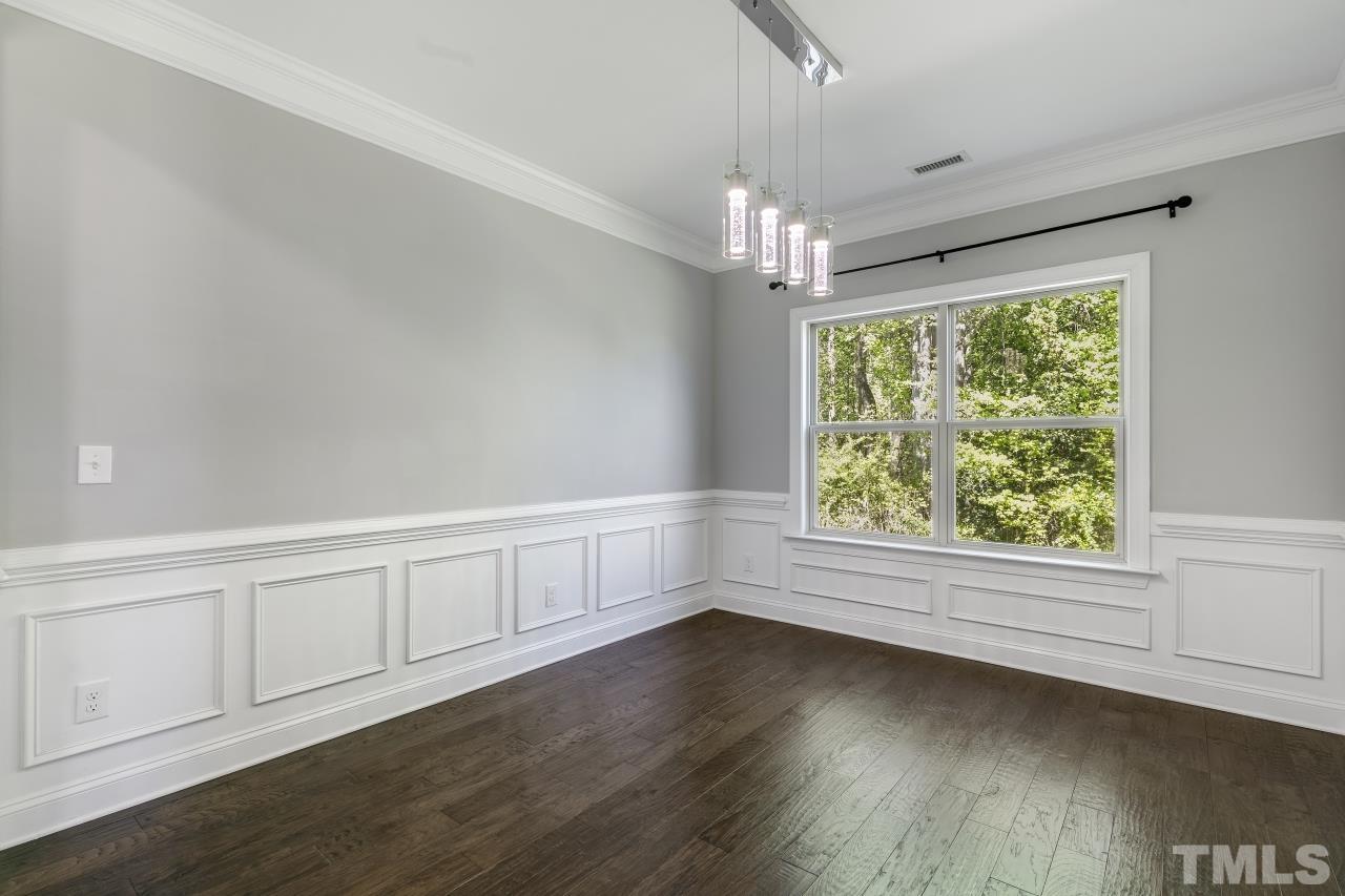 8340 Yellow Aster Court Willow Spring, NC 27592 - Photo 5 of 35 an empty room with wooden floor chandelier and windows