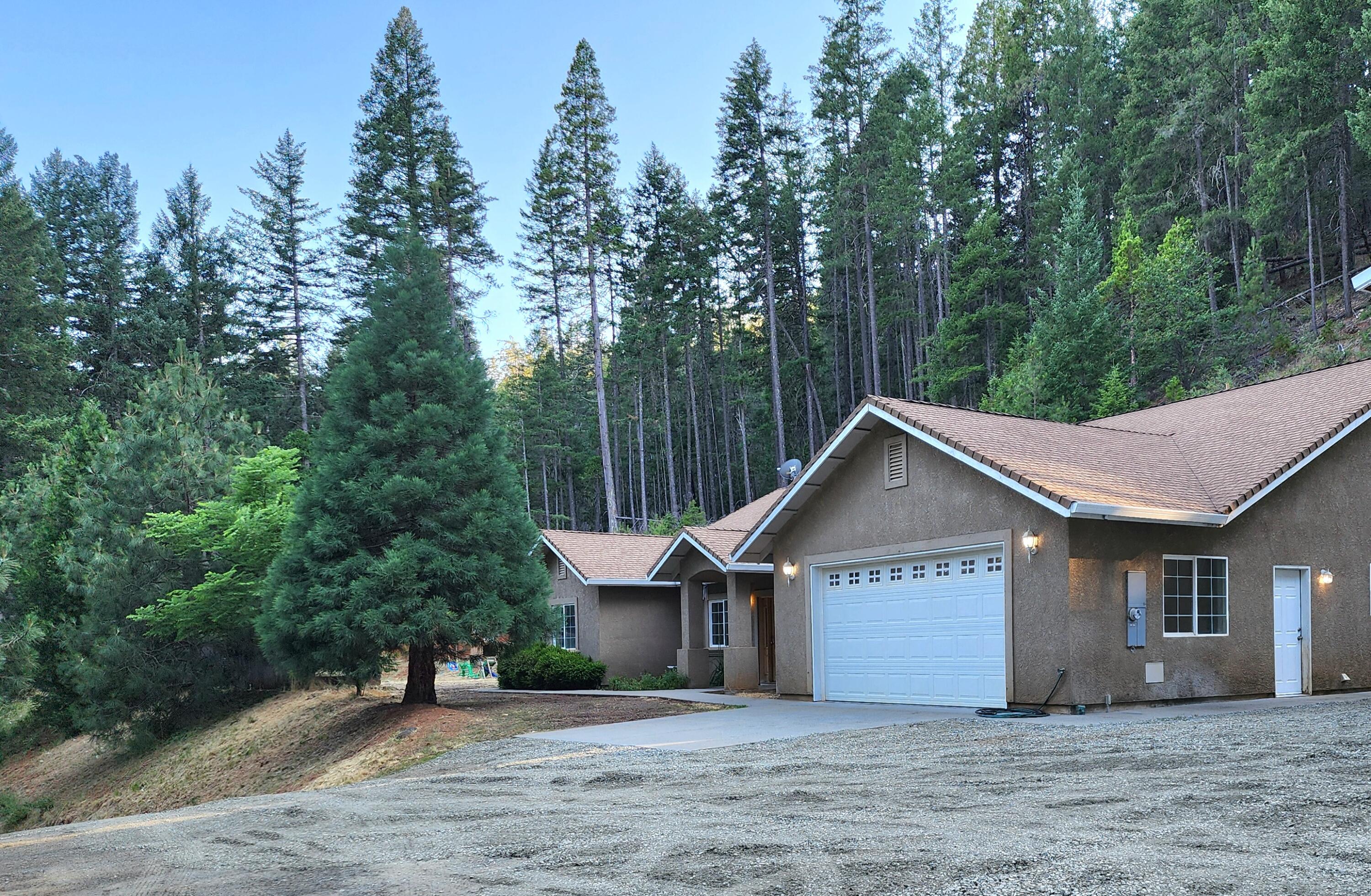 a front view of a house with a garden and trees