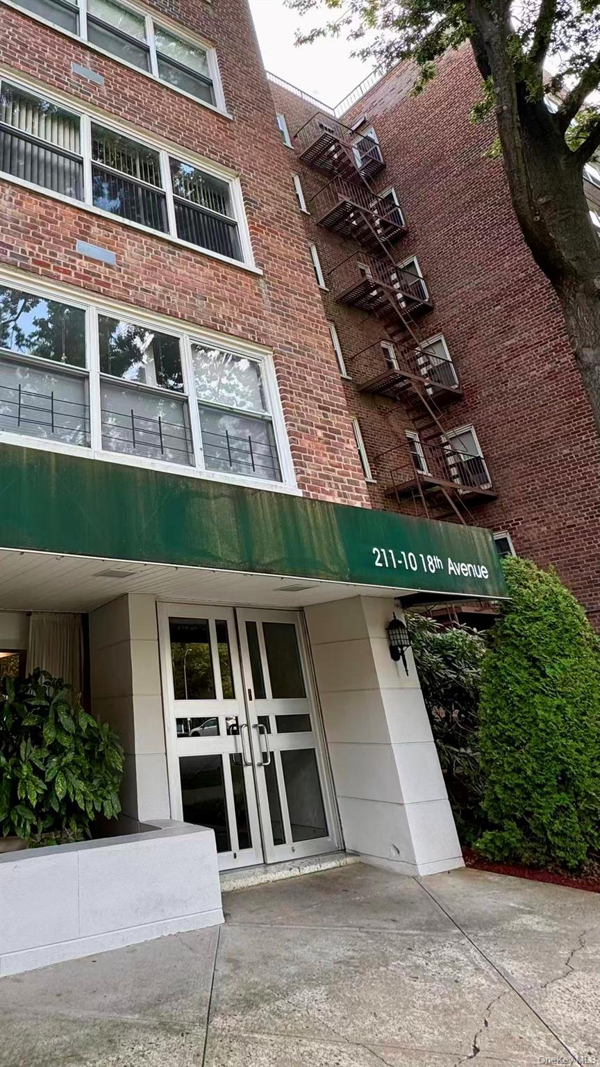 211-10 18th Avenue, Unit 6C Queens, NY 11360 - Photo 1 of 16 front view of a house with a street