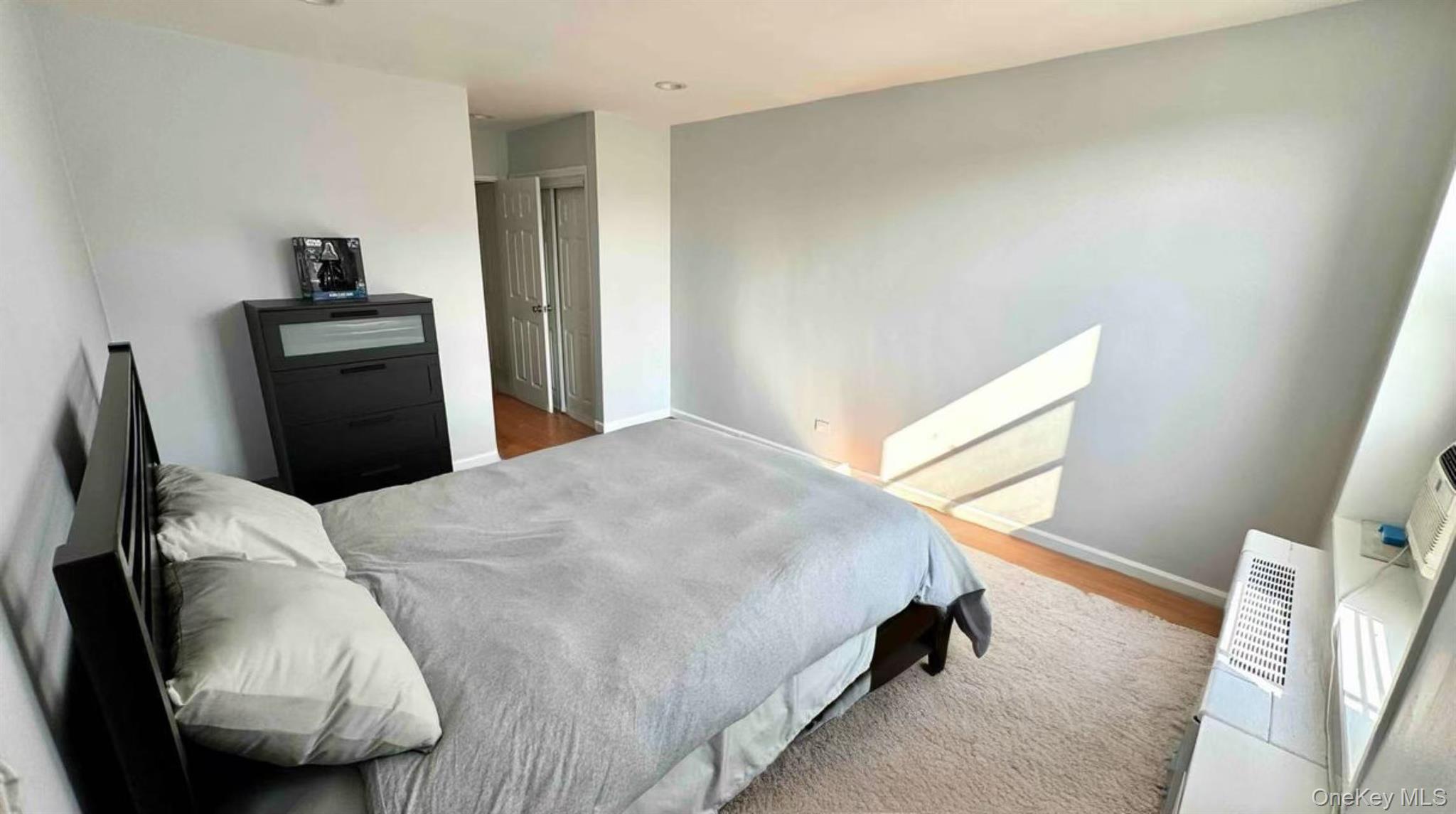 211-10 18th Avenue, Unit 6C Queens, NY 11360 - Photo 7 of 16 a bedroom with a bed and wooden floor